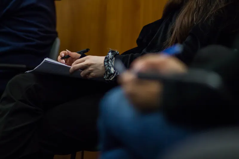Zbliżenie na dłonie notujące w zeszycie.